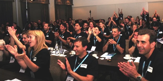 An audience applauding after a confident exit from a presentation