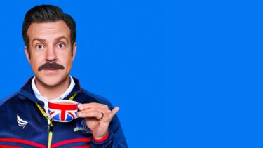 A picture of Ted Lasso holding a union flag on a blue background.