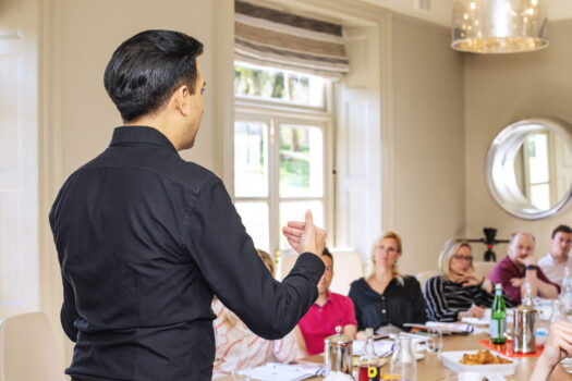 A communication coach speaking in front of a class.